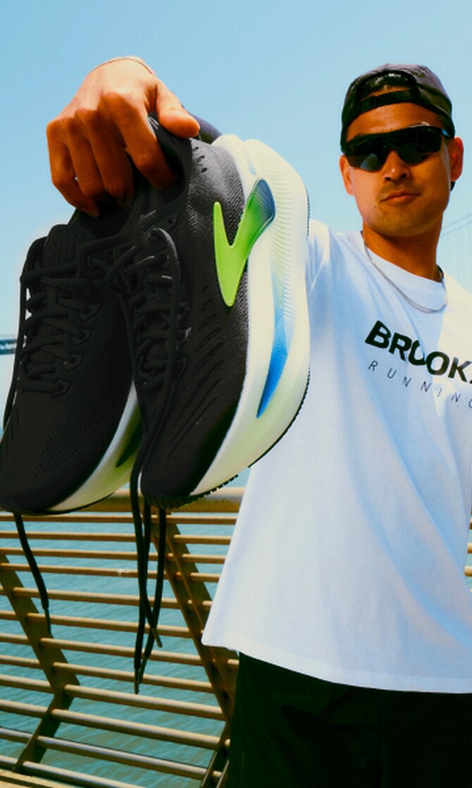 Uomo che indossa le scarpe da trail e i capi di abbigliamento più recenti firmati Brooks