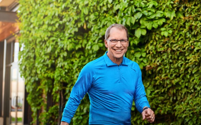 Jim Weber walking outside in blue long-sleeved shirt