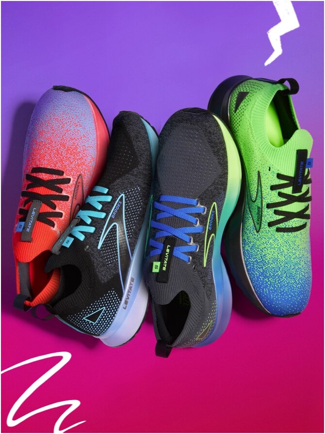 Four colorful shoes leaning against each other on pink and purple gradient background