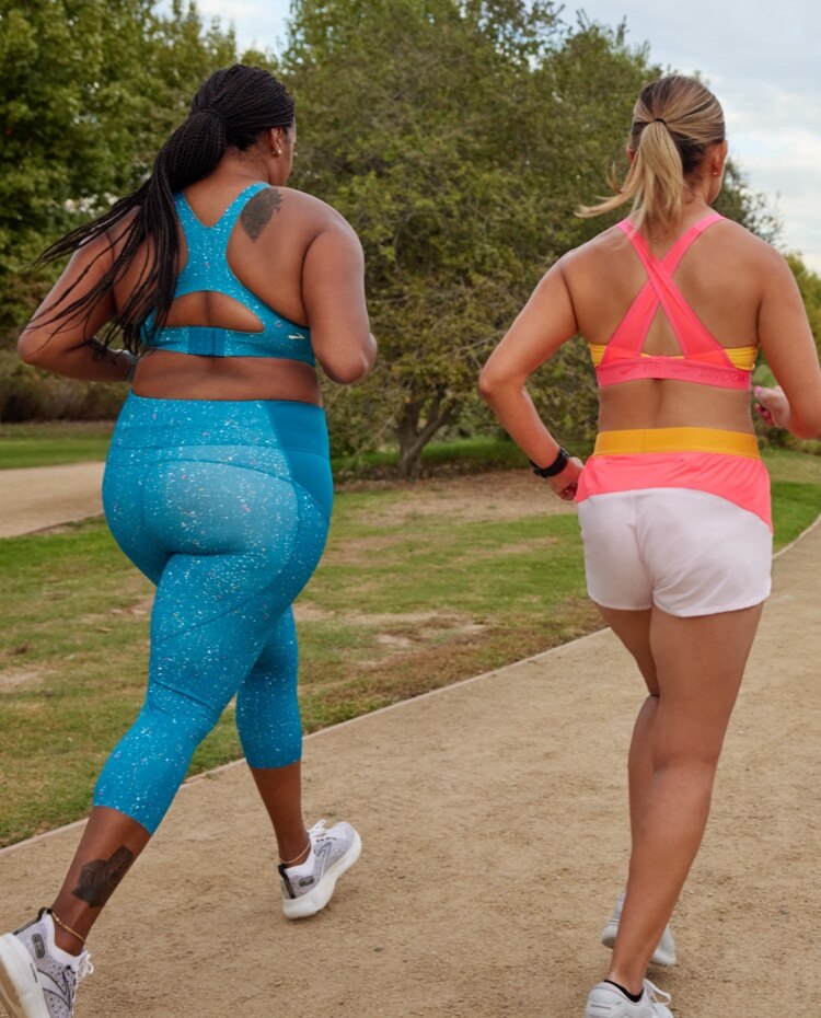 Vue arrière de deux coureuses qui portent des tenues de course bleues et roses