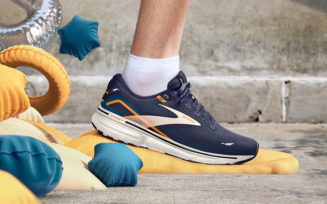 Dark grey running shoe landing on a yellow cushion