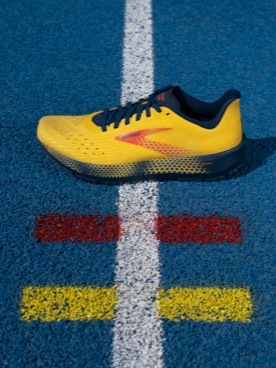 Yellow Brooks shoe on race track