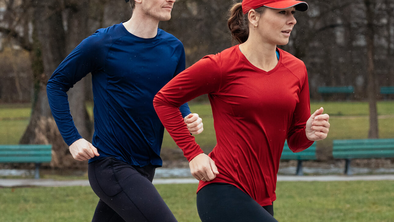 A pair of runners do their workout in base layer tops to stay cool and comfortable.