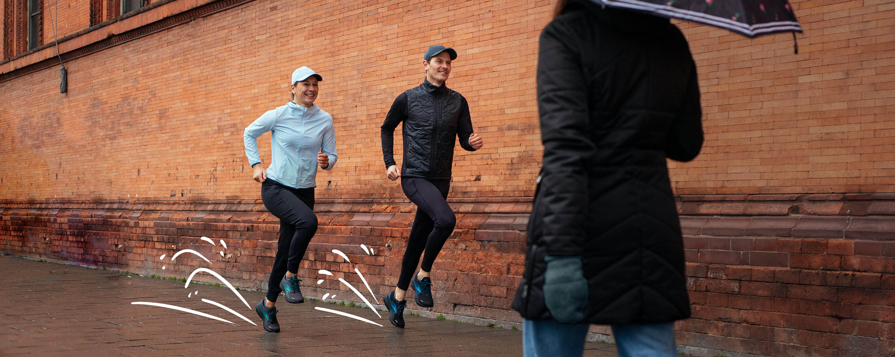 A pair of runners run along a rain-soaked street, layered up to face the weather head-on. 