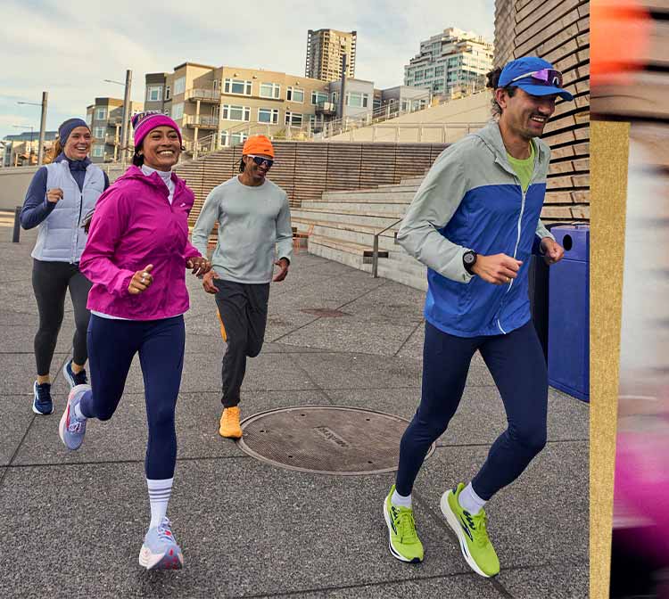 A group of people in bright gear run on a sidewalk