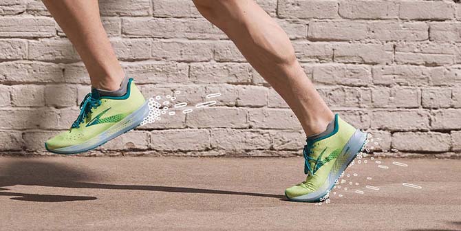 Side view of the bottom of runners' legs wearing green running shoes