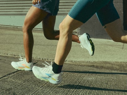 A pair of people running on a sidewalk in Brooks shoes