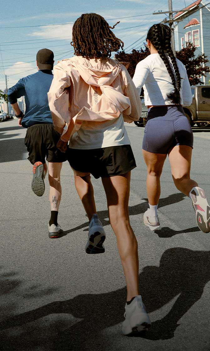 A group of people running outside on a sunny day