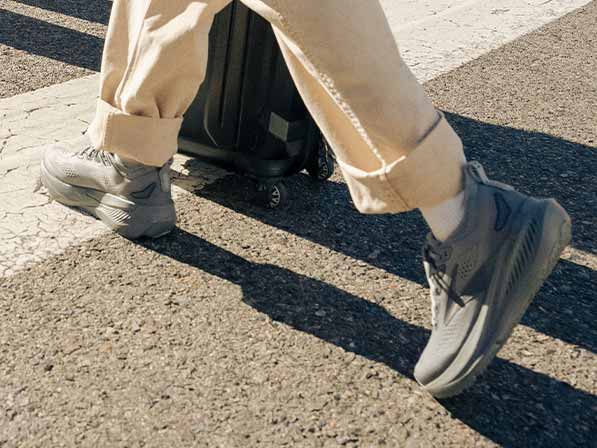A person in Brooks shoes walks across a crosswalk