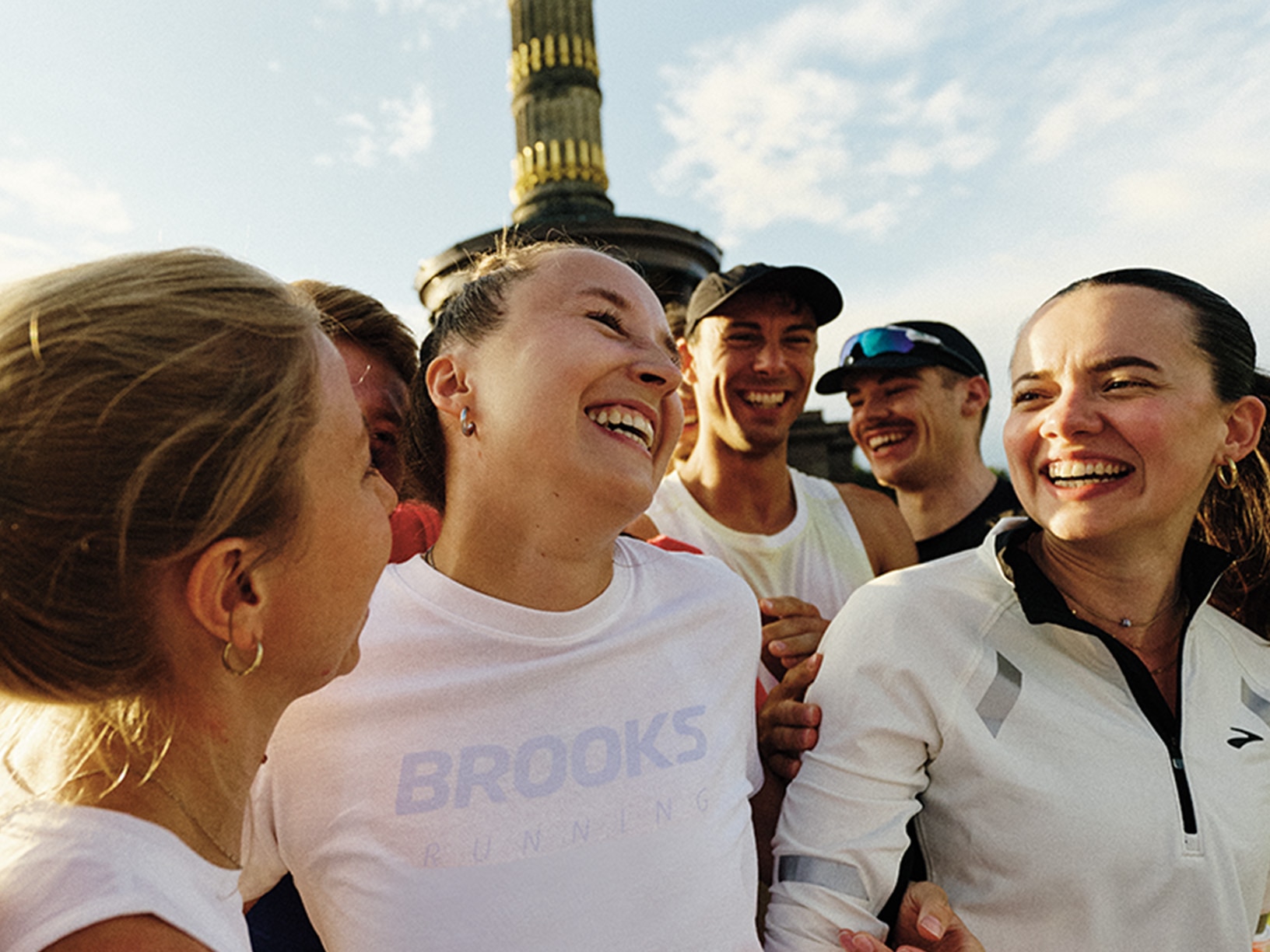 Un groupe de personnes portant des vêtements Brooks qui sourient à l’extérieur
