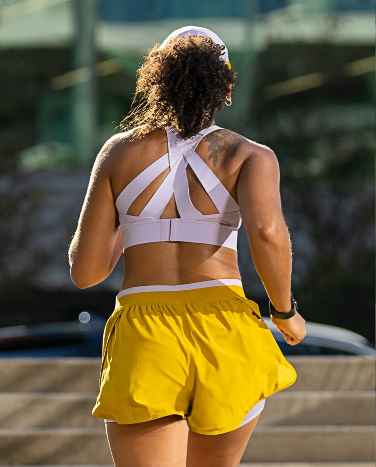 A close-up of a woman in a Drive Convertible Run Bra running on a path.