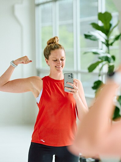 Women flexing arm in front of mirror