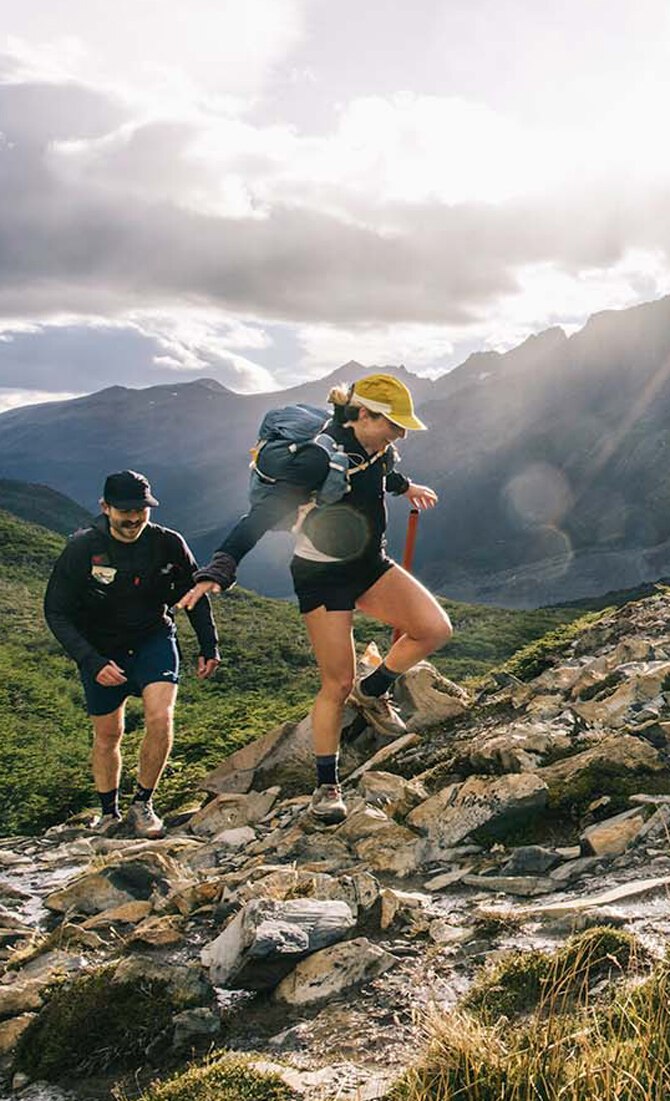 Two runners wearing Brooks apparel climbing a mountain