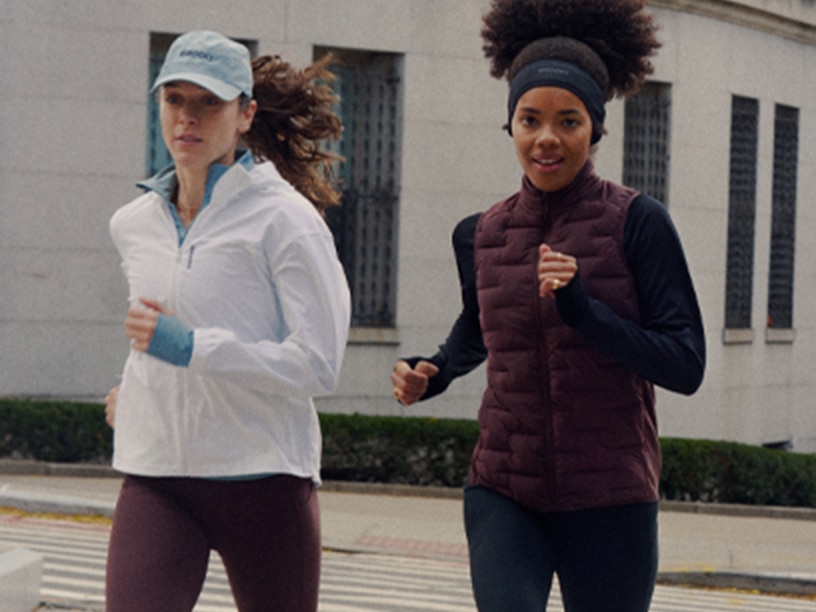 Two women running outside wearing Brooks apparel