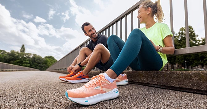 Prise de vue en contre-plongée d’une femme et d’un homme portant les chaussures de running Ghost MAX.