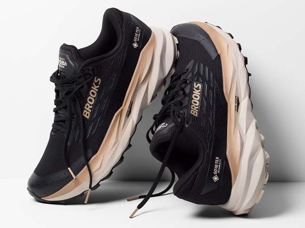 Black and gold Brooks men's shoes rest on a surface