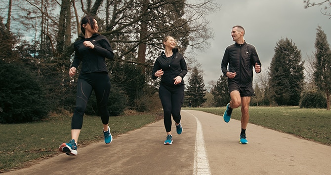 Medium shot of 3 runners wearing Brooks in the park