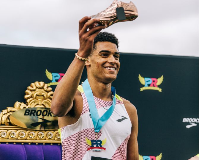 Coureur tenant un trophée en forme de chaussure