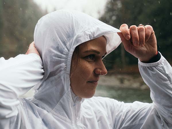 A woman wearing Brooks apparel against a natural background