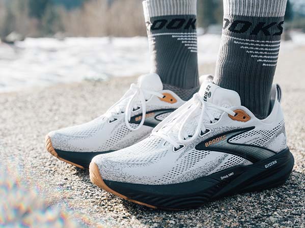 A person wears Brooks men's shoes in a snowy setting