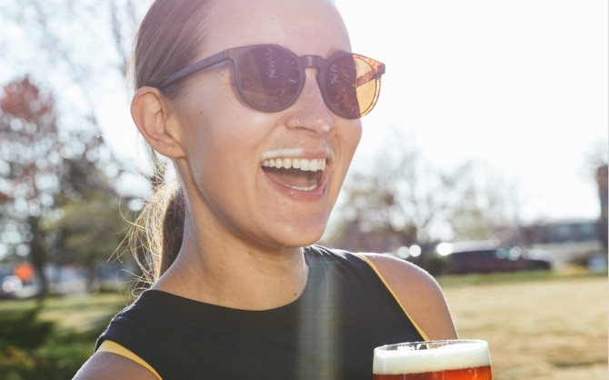 Femme souriante avec une bière