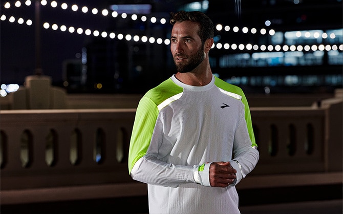 A runner in the dark wearing the Brooks Run Visible collection