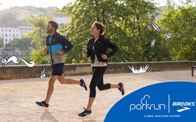 Two runners are running together in a park