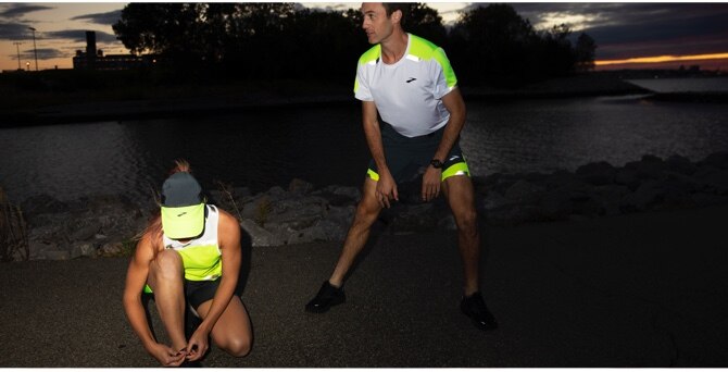 Two runners stretching at night