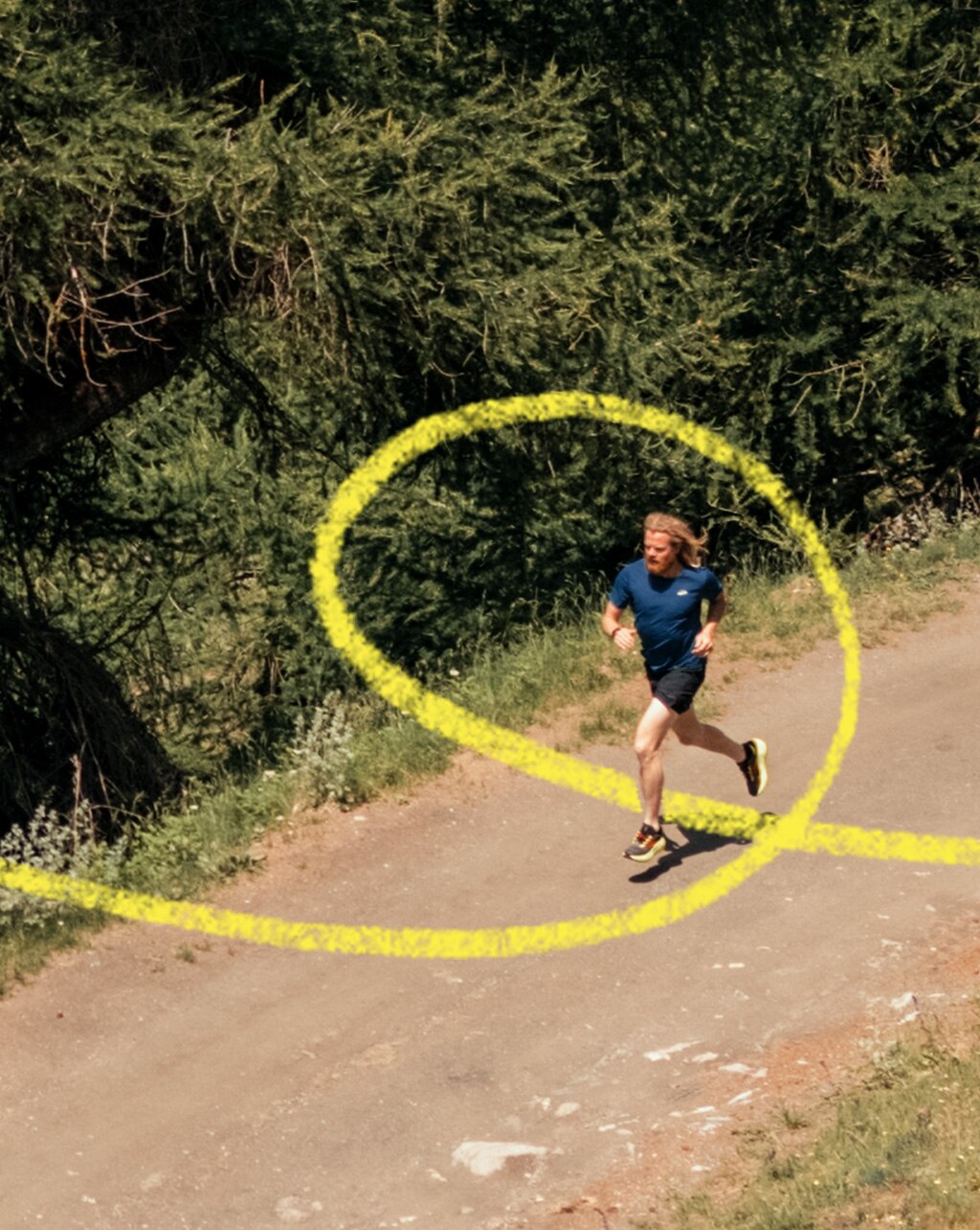 Mann auf einem Waldweg beim Trail Running