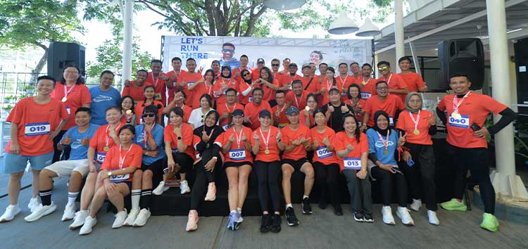 A group of people standing in front of a Brooks banner