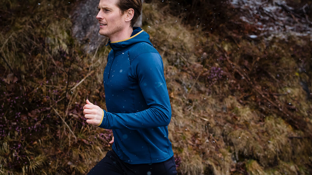 A runner stays warm while wearing a zip-up hoodie mid layer.