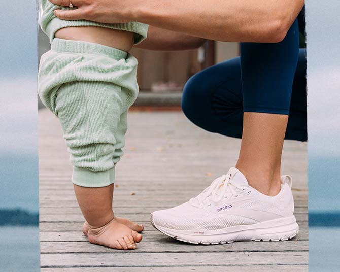 A baby and a woman stand together