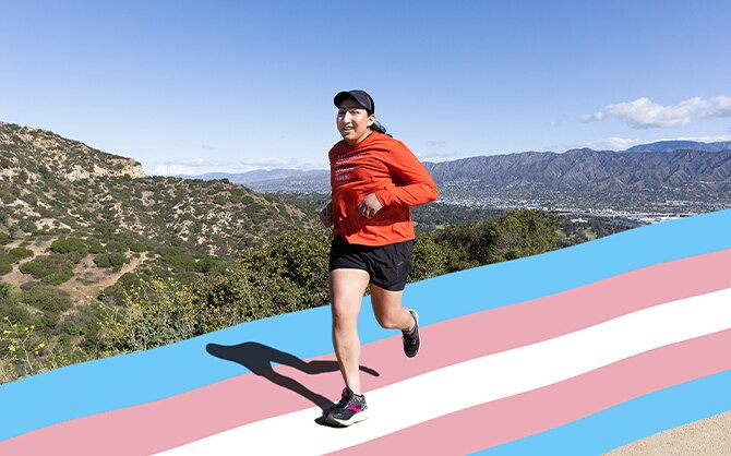 A runner outside on a trail in the shape and colors of transgender flag